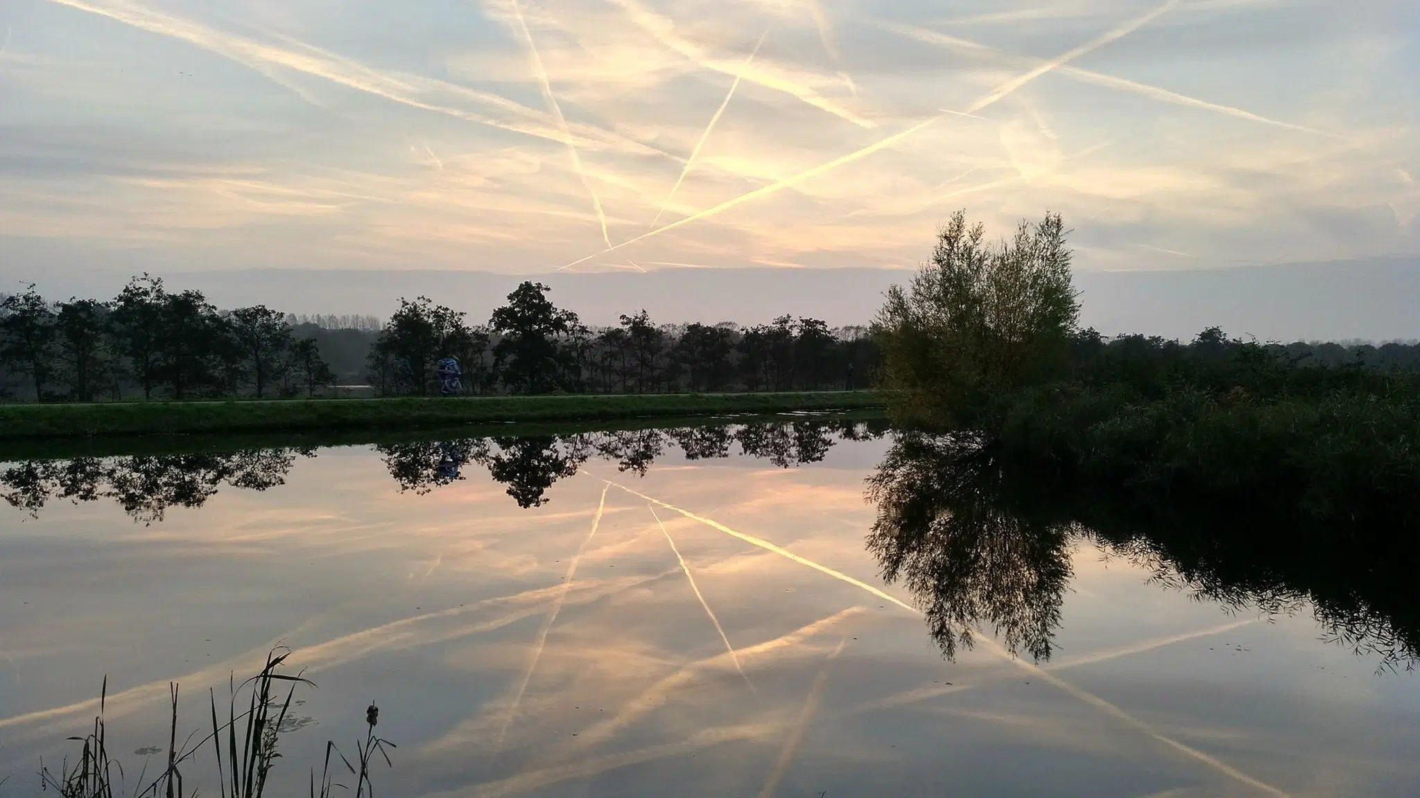 Sunset landscape with contrails