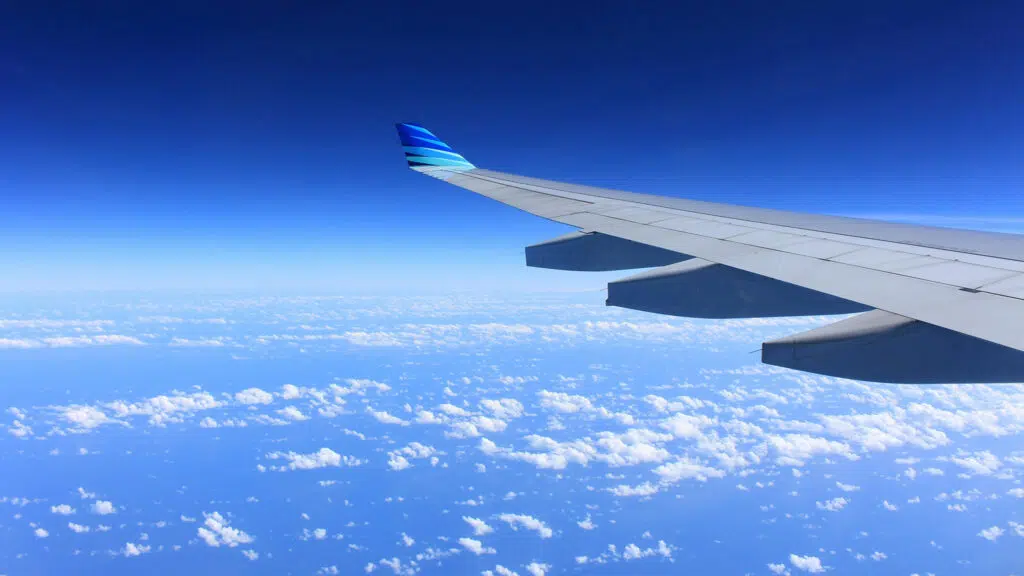 Blue sky with gray plane wing